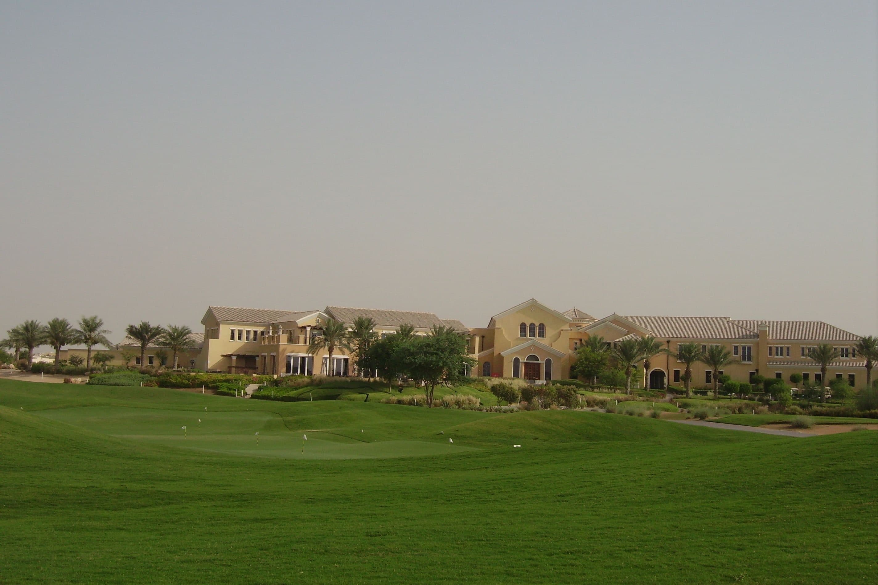 The Arabian Ranches Golf Club clubhouse behind its practice putting green and fairway