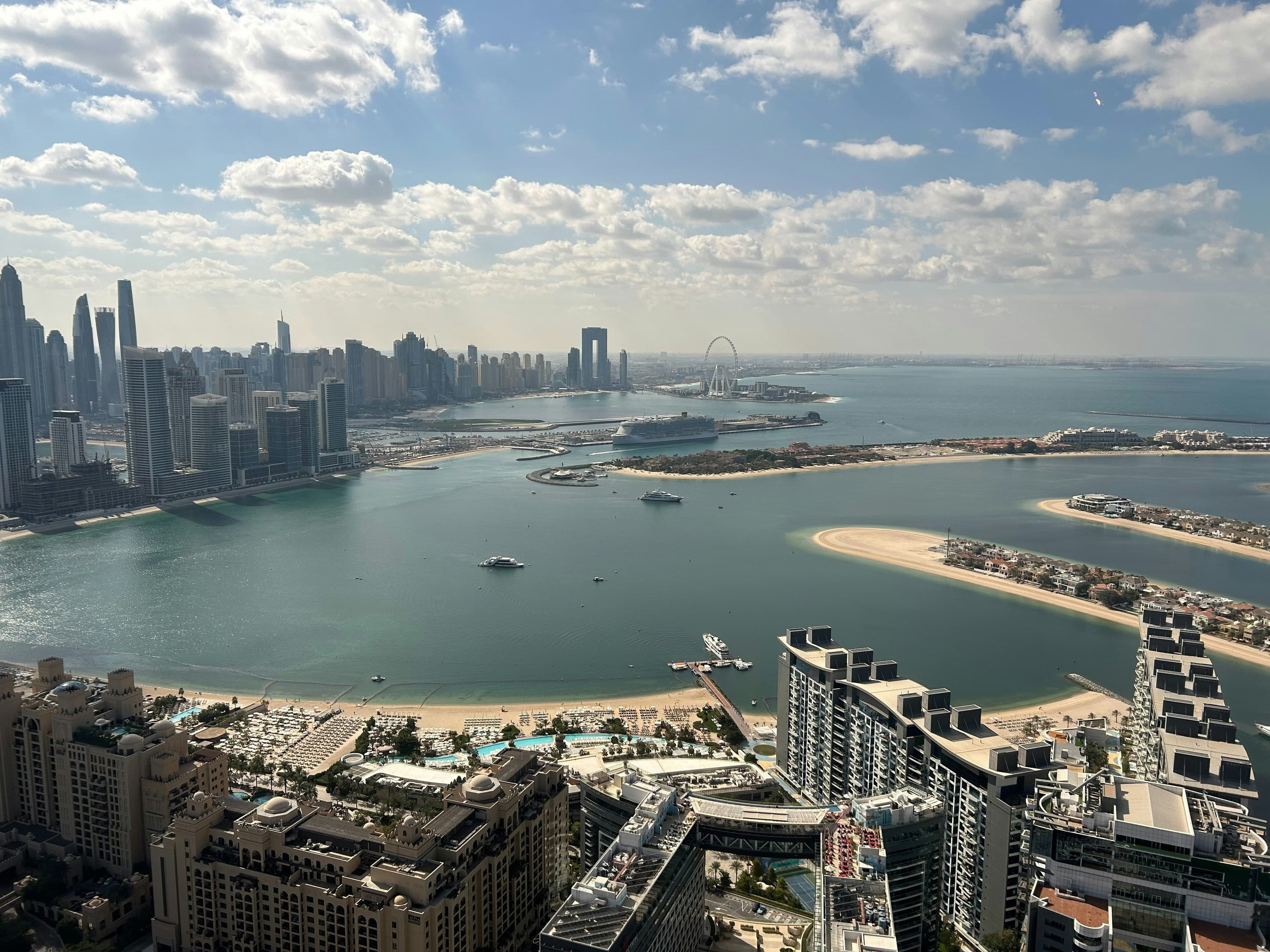 A cruise ship at the Dubai Harbour cruise terminal, with Emaar Beachfront and Dubai Marina on the left, seen from Palm Jumeirah